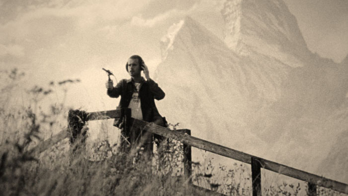 Jim Baitte (Jack Redmayne) stands on a hillside with recording gear in The Peril at Pincer Point.