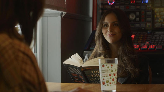 Meghan (Brianna Rose Seymour) sits reading in WallDale.