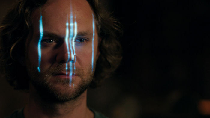 Bruce (Joseph Cross) with blue light across his face in Affection.