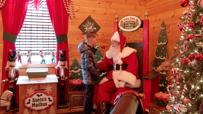 A child meets Santa in a decorated holiday room in Behind the Beard: Making Santa Real.