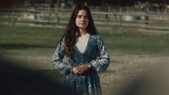 Emma (Ryann Bailey) standing alone in a rural field in By His Hand.