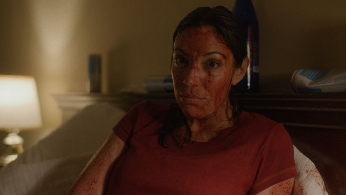 Stephanie Hogan covered in blood inside a motel room in I Know Exactly How You Die (2026)