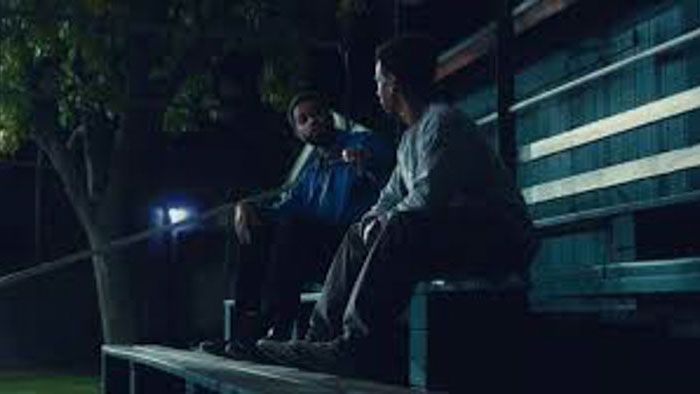 Jasper (Stephen Cofield Jr.) and Jamarcus Rose (Duane Ervin) talking on the bleachers at night in Jamarcus Rose & Da 5 Bullet Holes.