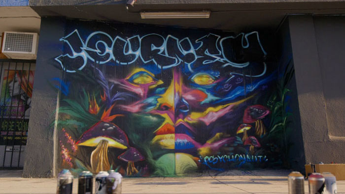 A colorful graffiti mural reading "Journeys" with psychedelic mushroom imagery in Journeys (2026).