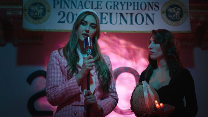 Two women on stage at the Pinnacle Gryphons 20th high school reunion in Reunion