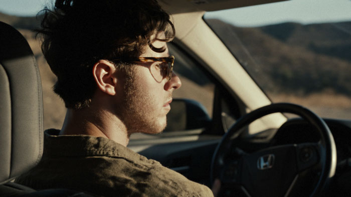 Ethan (Nolan Gould) drives along a remote road in The Liars of Black Mountain Road.