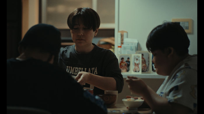 Maïto shares a meal at a dining table in Benjamin Nicolas's documentary A Quiet Storm.
