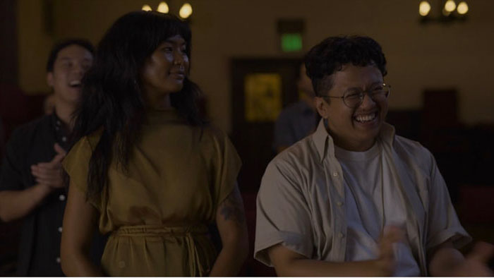 Ashley (Anaïs Noveras) and Francis (Reden Magtira) smile together at a social gathering in Good Filipino Kids. 
