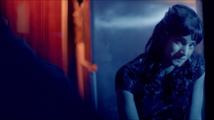 Vix (Sofia Boutella) appears under blue neon light in Jet Trash.