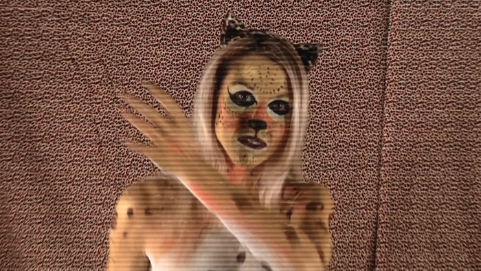 A body-painted character appears in a surreal scene from Killer Thong.