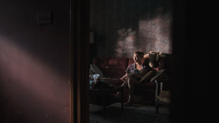 Pénélope (Rose-Marie Perreault) and Edward (Saladin Dellers) in a dimly lit interior in Nesting.