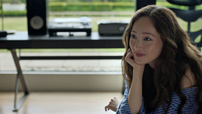 Marcia (Havana Rose Liu) sits by a window in Power Ballad.