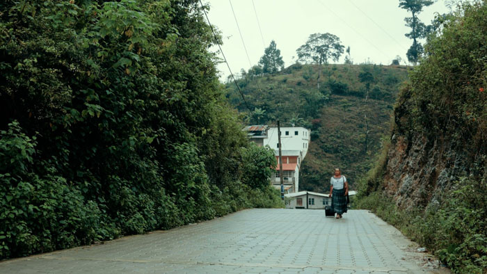 Mónica Chub Caal walks along a rural road in IXIM (el amor no tiene género). 