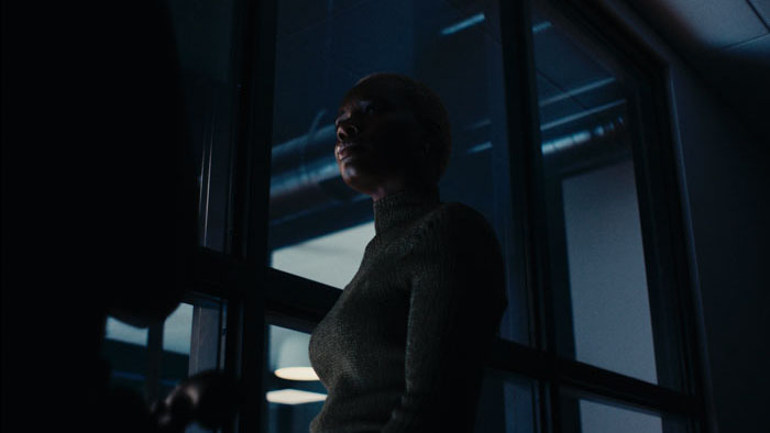 A woman stands in shadow at night in Night After Night.