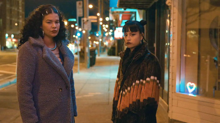 Madison (Star Slade) and Nika (Ellyn Jade) stand on a city street at night in Nika & Madison.