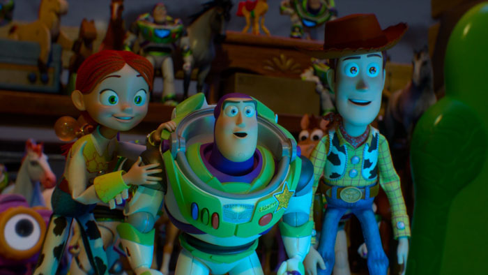 Jessie, Buzz, and Woody stand together among toys in a nighttime scene from Toy Story 5.