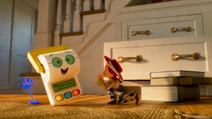 Jessie kneels beside Lilypad, the toy tablet, in a stairwell scene from Toy Story 5.