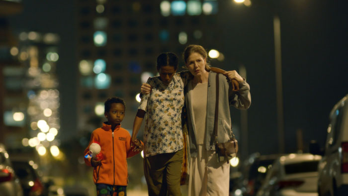 Yehudit supports a pregnant Meron and her young son walking at night in What Is to Come. 