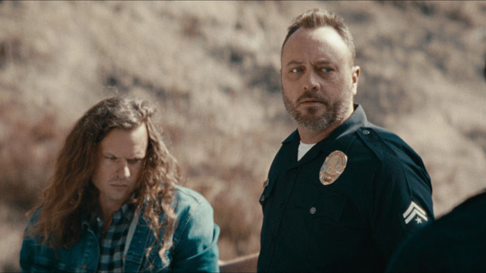 Riley Dawson (Patrick Scott Lewis) stands over Carl (Drew Logan) during a search in Shift.
