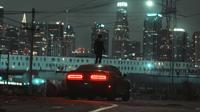 The masked vigilante (Johnny Yong Bosch) stands atop a car against a night skyline in Spades.