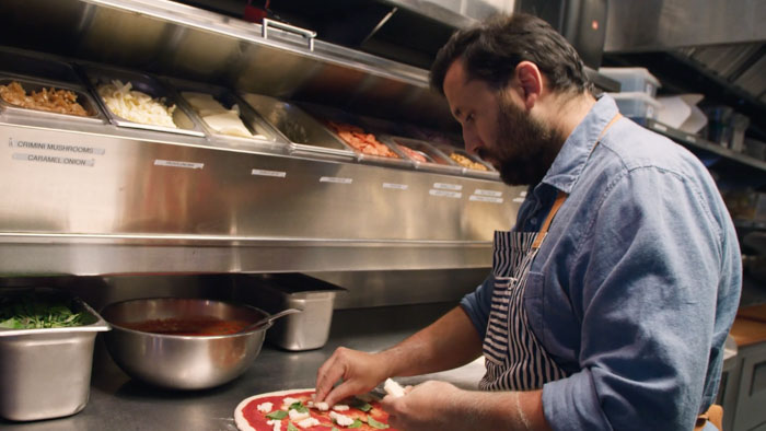 A chef prepares a fresh pizza in a restaurant kitchen in The Best Pizza Is In L.A.