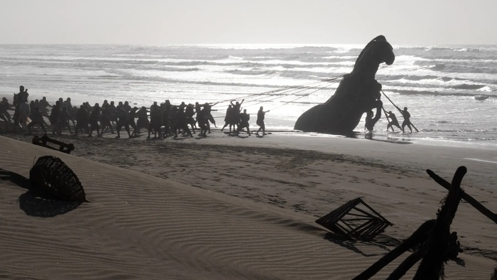 Greek soldiers haul the Trojan Horse ashore with ropes in The Odyssey.