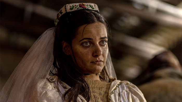 The bride (Isidora Simijonović) stares ahead during a grim ritual in Warriors of the Wasteland.