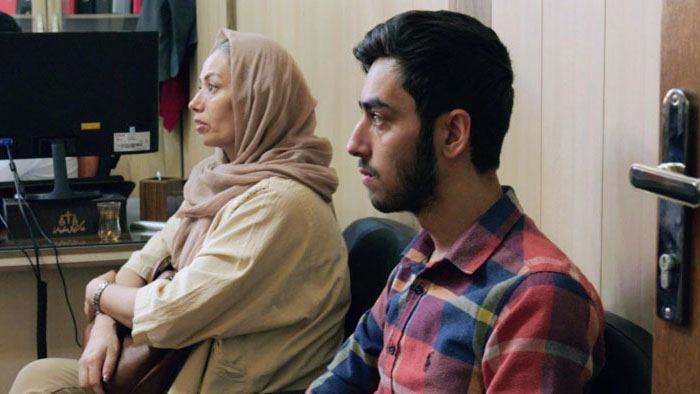Taherah sits with her son in a waiting room in An Eye for an Eye.