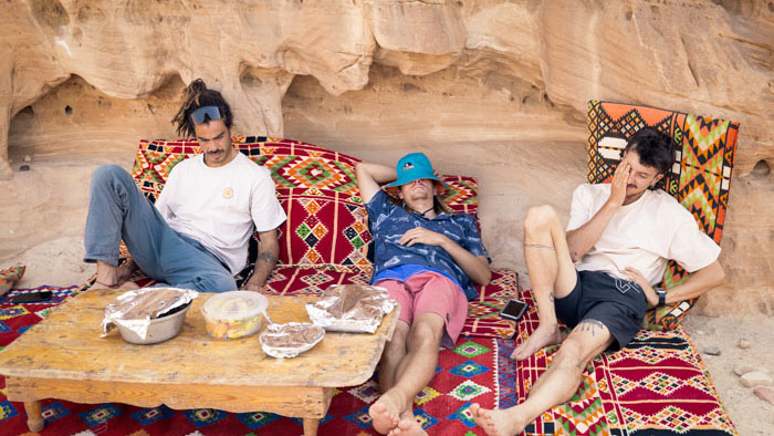 The Another Way team rests on Bedouin cushions and shares a meal at a rock face in Egypt's Sinai desert.