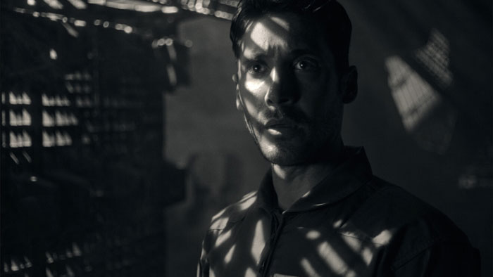 Freddie Ballard (Guy Kent) stands tense in shadow-streaked light aboard his spacecraft in Aurora.