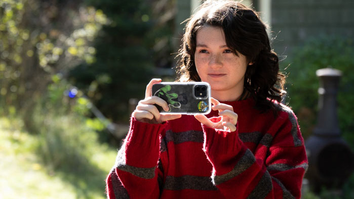 Bridget Benally (Ambrose Velasco Jenkins) films outdoors with a phone in Bigfoot Woods.