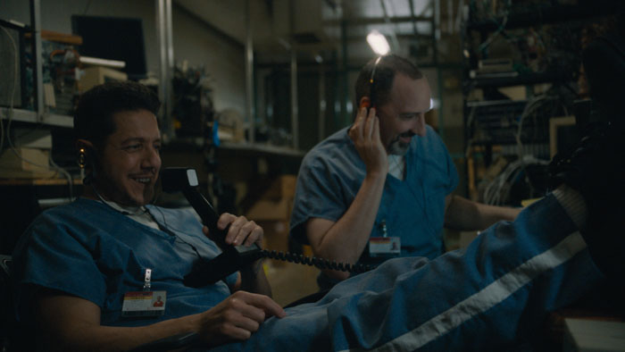 Bryan Bruton (Theo Rossi) and Kai (Tony Hale) share a laugh on the phone in Bruton.