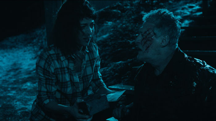 Julia (Emmanuelle Lussier Martinez) confronts a wounded Randall (Bill Rowat) at night in Bury the Devil.