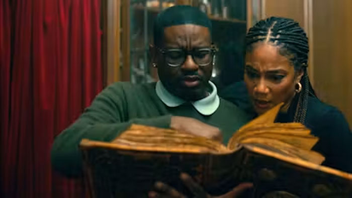Ron (Lil Rey Howery) and Shari (Tiffany Haddish) examine an ancient book in Haunted Heist.