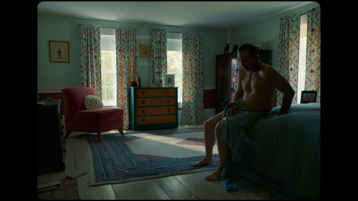The Man (Guy Ventoliere) sits on the edge of a bed in How the Lonely Keep.