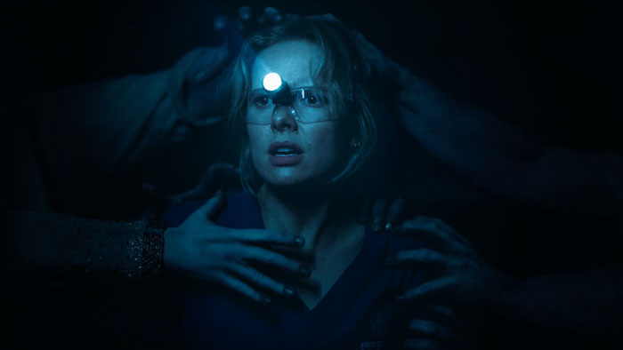 Gemma (Amelia Eve) is seized by ghostly hands during a dental exam in Insidious: Out of the Further.