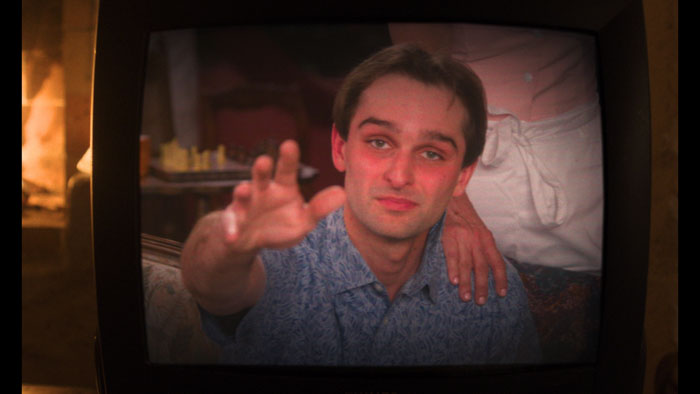 Vincent (Andrew Gabriel) reaches toward the screen from inside the TV in Life At Sandy's.