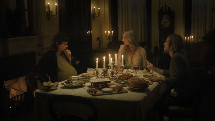 Sara (Chloe Van Landschoot) at a candlelit dinner with Jane Moffat and Garrett Hnatiuk in Son of Sara: Volume One.
