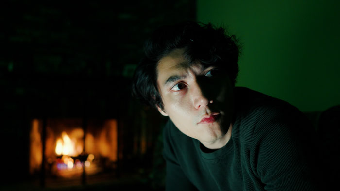 Nathan Noble (Andrew Beall) sits by a fireplace in a tense moment from Tempest.