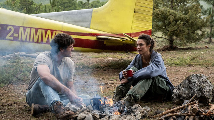 Jacob Elordi as Hig and Margaret Qualley as Cima share a campfire in The Dog Stars.