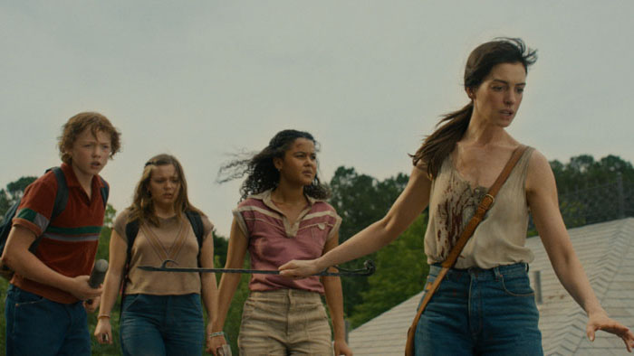 Denise (Anne Hathaway), Audrey (Maisy Stella), Brian (Christian Convery), and a neighbor walk through Oak Street.