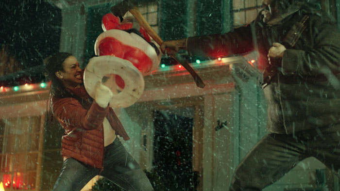 Lucia (Toni Ellwand) fights off an axe-wielding attacker amid Christmas lights in Unholy Night.
