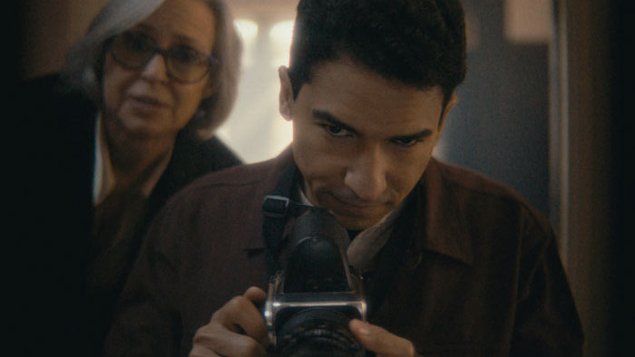 Abel (Steven Staine Fernandez) looks through a camera as Sylvia (Maritza Vives) watches in A Burial.
