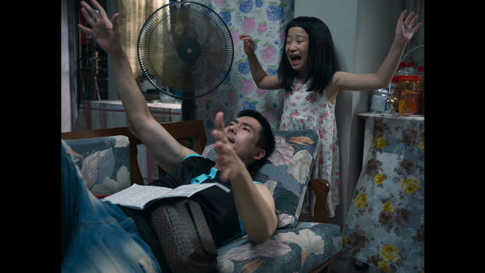 Swee Swee (Ong Xuan Jing) glances back with a wary expression in a schoolyard scene from Ah Girl.