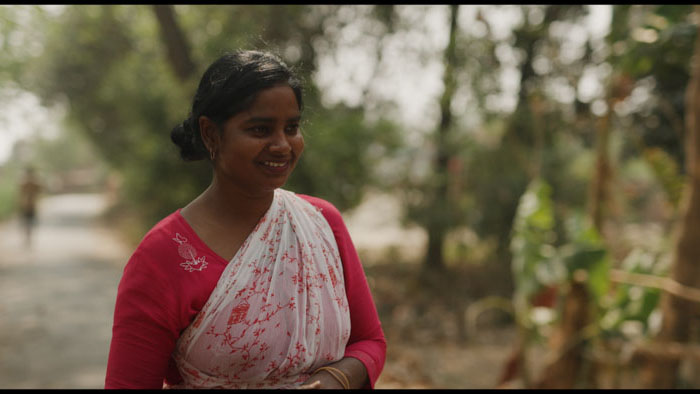Babita smiles outdoors in a scene from the documentary short From Fields to Flight.