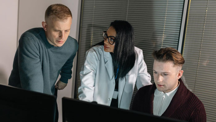 MI5 analysts huddle around computer monitors in a tense scene from Knightfall.