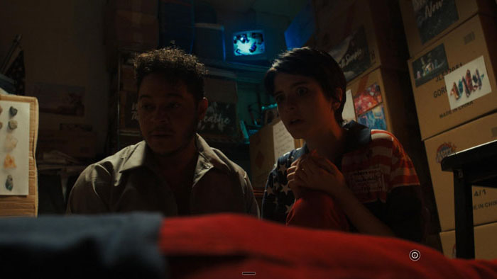 Taylor (Ainsley Seiger) and Damian (Phillip Andre Botello) react with alarm in a cluttered room in Party USA.