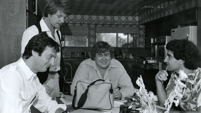 Joe Flaherty, Dave Thomas, John Candy and Eugene Levy at a table in an archival photo from the SCTV documentary.