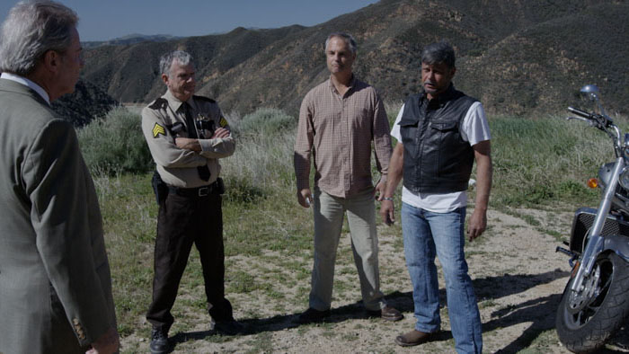 Dr. Goode (Jeffrey Kaye), Sheriff Taggart, Toto, and Karp confront each other in The Lone Road.